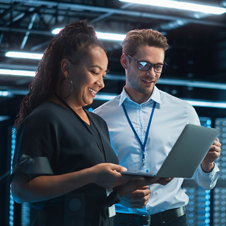 A female and male colleagues looking at laptop screen.
